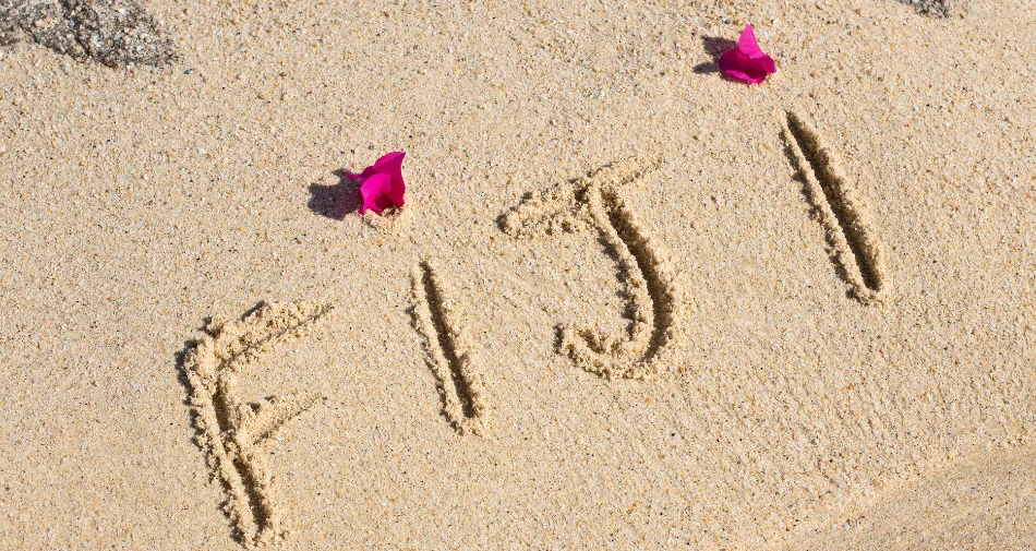 Napis "Fiji" wygrawerowany na plażowym piasku