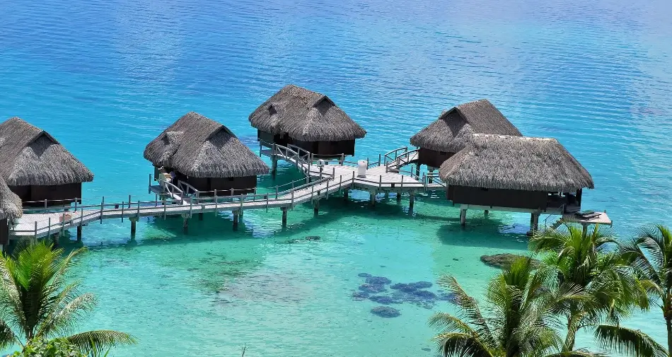 Widok na drewniane bungalowy na lagunie na wyspie Bora Bora, Polinezja Francuska