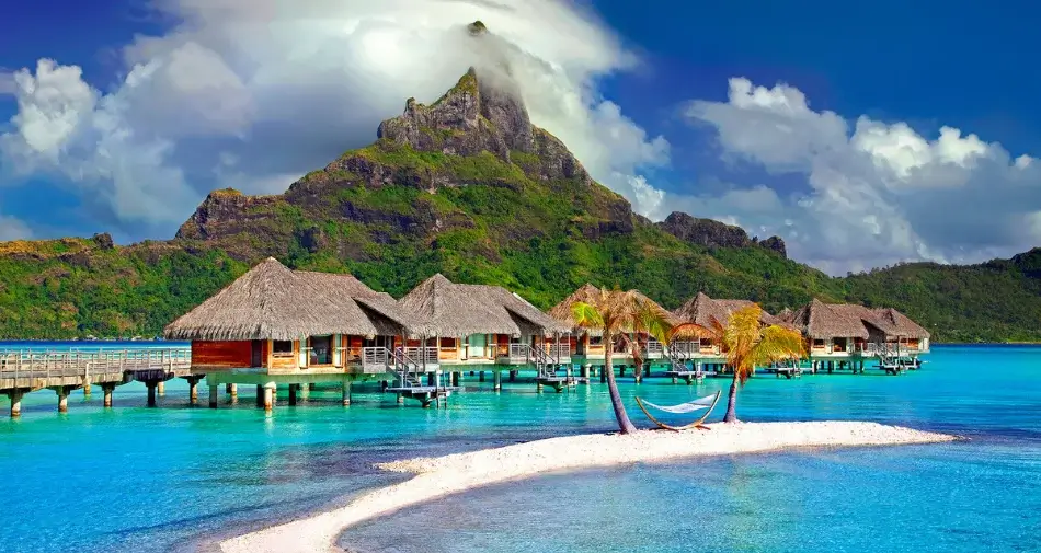 Drewniane bungalowy na tle wulkanu na wyspie Tahiti, Polinezja Francuska
